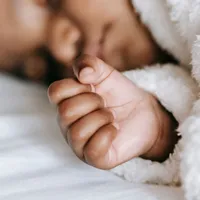 Bebê dormindo tranquilo, enrolado em um cobertor macio