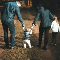 Família caminhando de mãos dadas ao entardecer